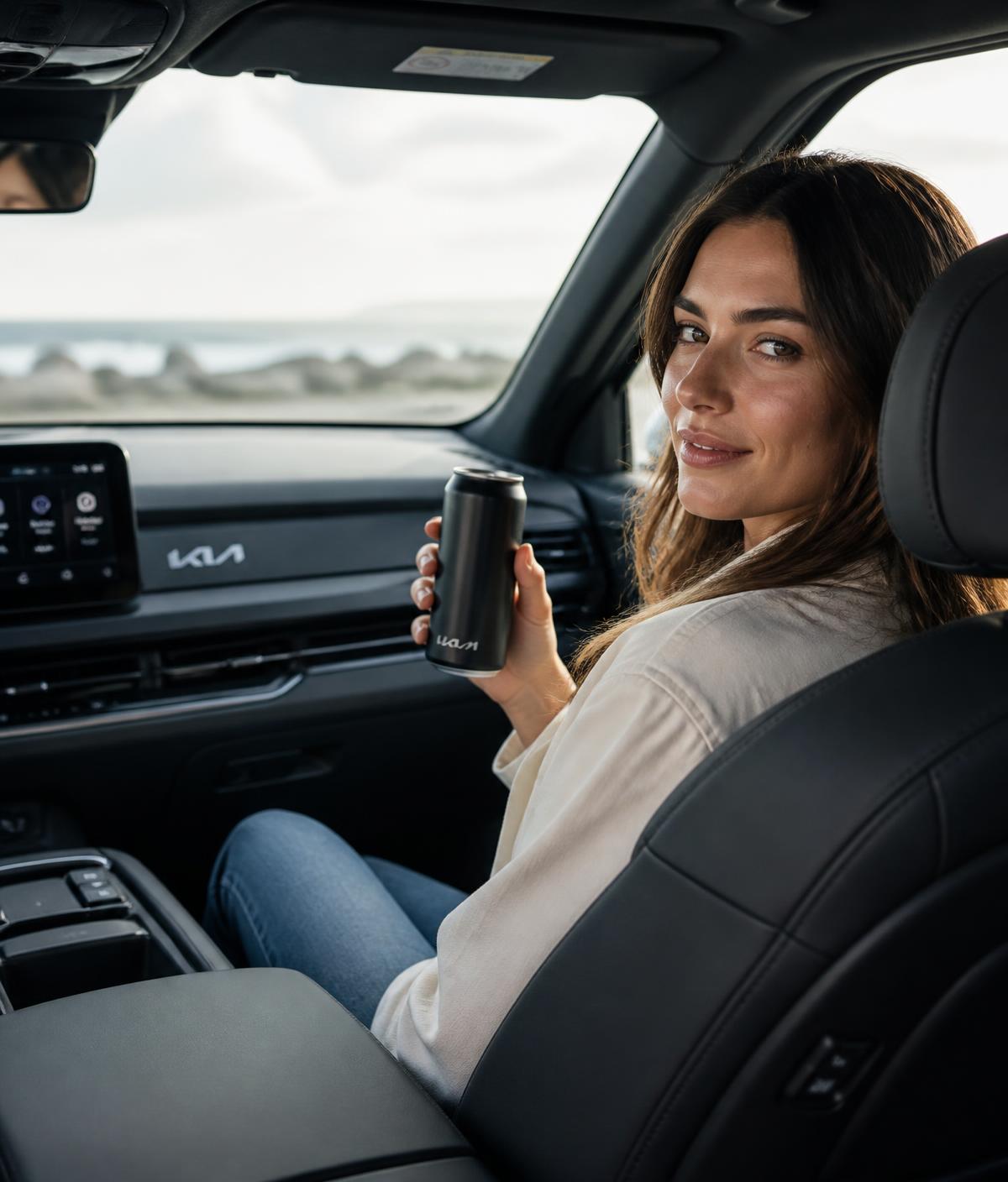 A woman in a new Kia SUV holding a custom-branded matte black can